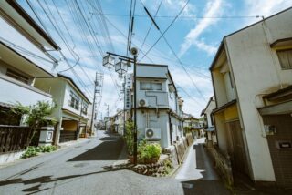 Explore a picturesque narrow street lined with traditional houses under a clear blue sky.