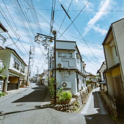 Explore a picturesque narrow street lined with traditional houses under a clear blue sky.