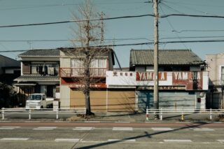 A closed Yamaha dealership on a quiet urban street in Toyohashi, Japan, featuring traditional architecture and empty roads.