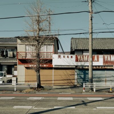 A closed Yamaha dealership on a quiet urban street in Toyohashi, Japan, featuring traditional architecture and empty roads.