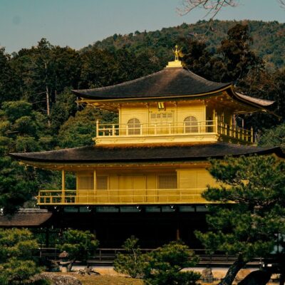 A stunning view of the Golden Pavilion surrounded by lush greenery in Kyoto, Japan.