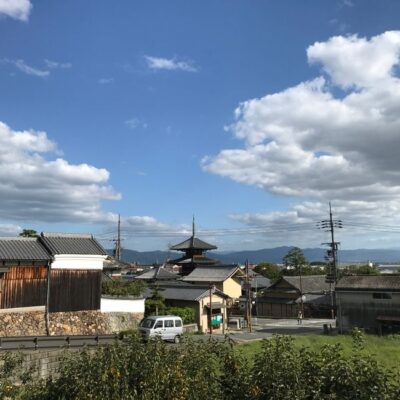 Scenic view of a traditional Japanese town featuring a pagoda under a clear blue sky.