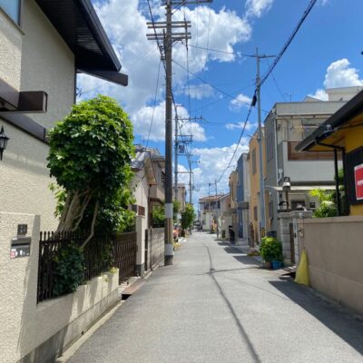 Charming view of a sunny residential street in Osaka, showcasing traditional and modern architecture.