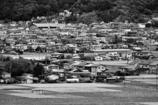 Black and white view of Suwa town showcasing architecture and landscape.