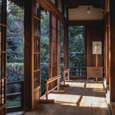 A serene view of a sunlit traditional Japanese tea house interior with wooden architecture.