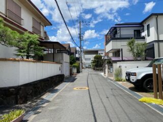 Sunny residential street in Osaka showcasing traditional and modern Japanese architecture.