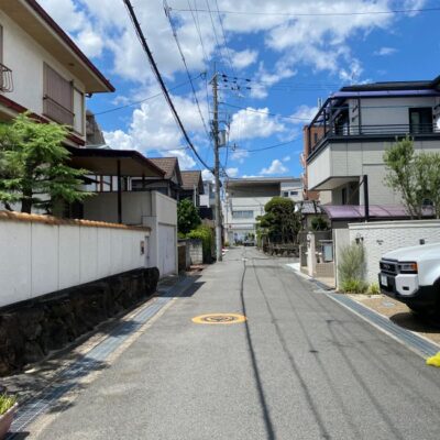 Sunny residential street in Osaka showcasing traditional and modern Japanese architecture.