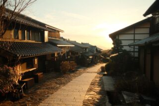 Charming view of a historic Japanese village street with wooden houses at sunrise.