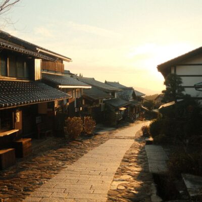 Charming view of a historic Japanese village street with wooden houses at sunrise.