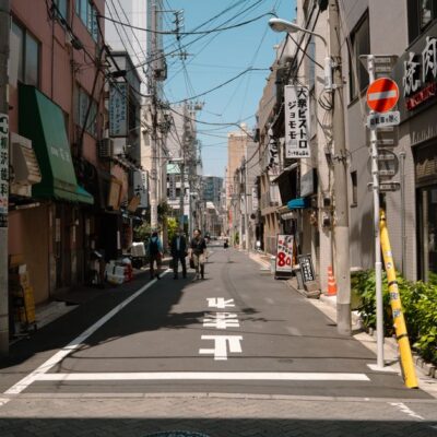 A quiet street in Tokyo, showcasing urban life and traditional architecture on a sunny day.