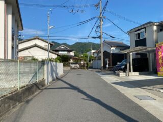 A serene street in Ikoma, Japan, showcasing traditional architecture and a mountain backdrop.