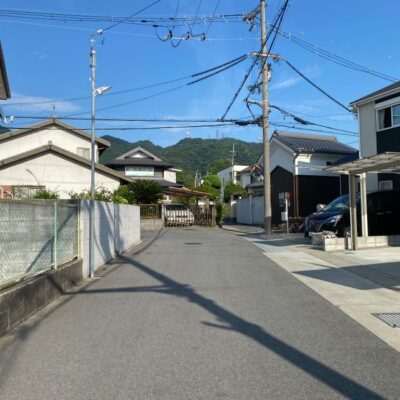 A serene street in Ikoma, Japan, showcasing traditional architecture and a mountain backdrop.